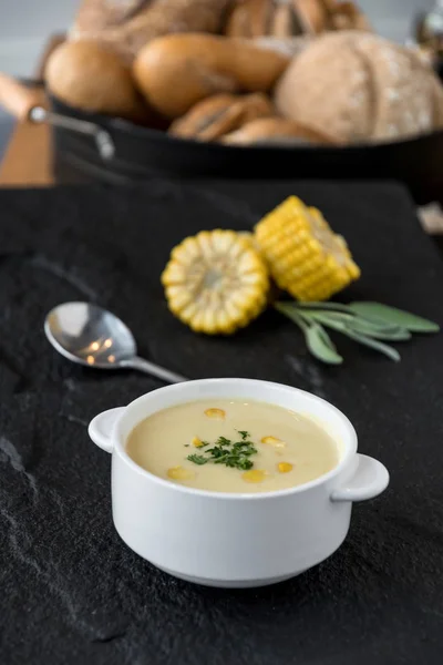 Delicious corn soup in bowl with fresh corn cob.