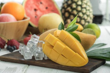 Ünlü Alphonso mango dilimleri farklı meyve ile ahşap arka plan üzerine.