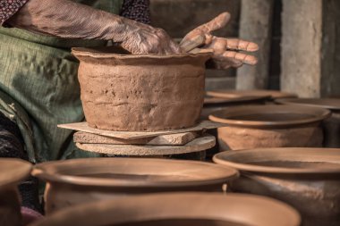 Bayan potter Yeşil önlük kahverengi kil kase heykel.