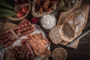 Ekmek lezzetli adet dilimlenmiş jambon, sosis, domates ahşap tablo.
