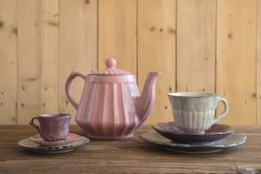 Demlik çay bardaklarından ve ahşap masa ahşap duvar arka plan ile plakaları ile.