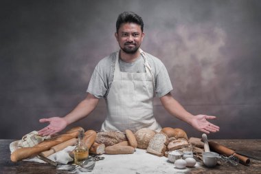 Taze pişmiş ekmeği ve ekmek ile masada duran mutlu Asya aşçı.