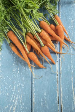 Havuç grup mavi ahşap masa, sağlıklı gıda üzerinde.