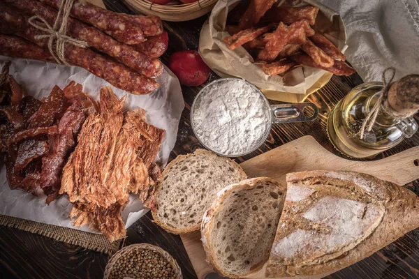 Ev yapımı ekmek dilimlenmiş jambon, sosis ve ahşap masa sebze ile.