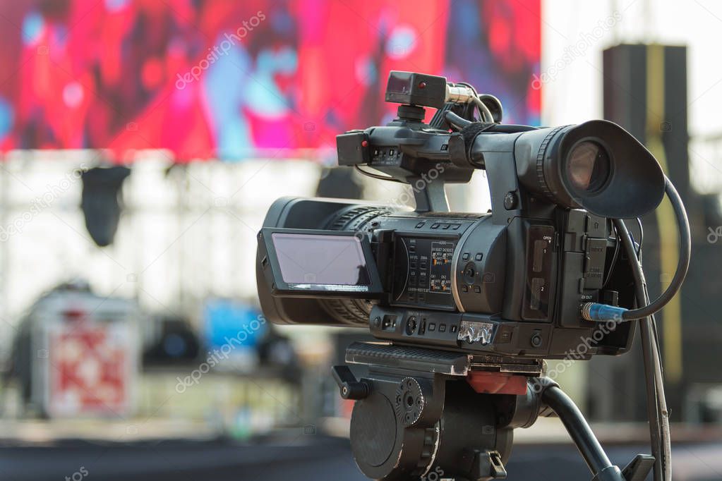 Video production covering event on stage by professional video camera in outdoor concert.