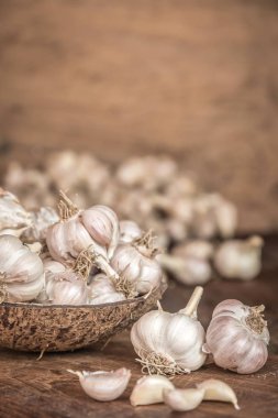 Ahşap tahta üzerinde sarımsak ampuller Hindistan cevizi kabuğu görünümünü kapat.