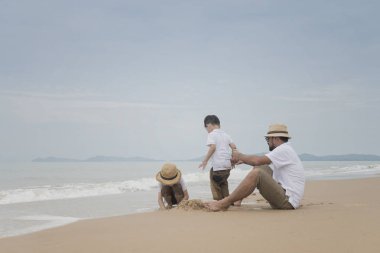 Asya Baba oğulları kasvetli gün kumsalda oynarken