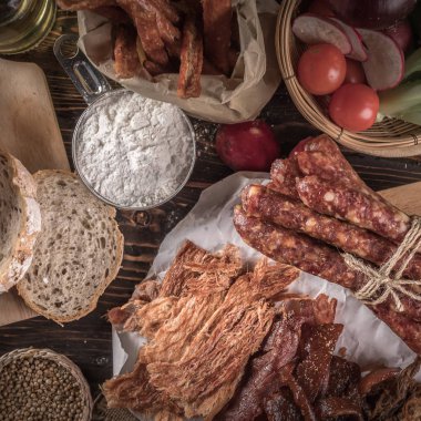 Ekmek lezzetli adet dilimlenmiş jambon, sosis, domates ahşap tablo.