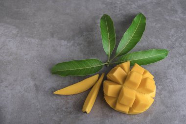 Mango koyu arka plan üzerinde yeşil yaprakları ile dilimlenmiş