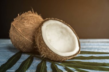 Eski mavi ahşap masa üzerinde palmiye yaprağı taze hindistancevizi.