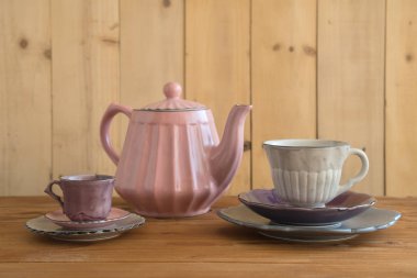 Demlik çay bardaklarından ve ahşap masa ahşap duvar arka plan ile plakaları ile.