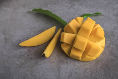 Ham olgun dilimlenmiş mango meyve yaprakları gri arka plan üzerinde ile