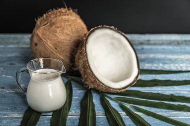 Taze Hindistan cevizi Hindistan cevizi sütü ve eski ahşap masa palmiye yaprağı ile.