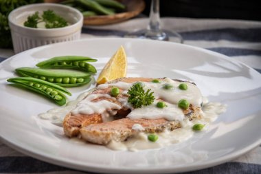 Limon ve beyaz tabakta sebze ızgara somon biftek.