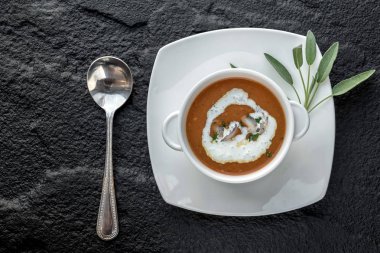 Kara taş yüzeyi beyaz kase karides ile krem çorbası üstten görünüm.