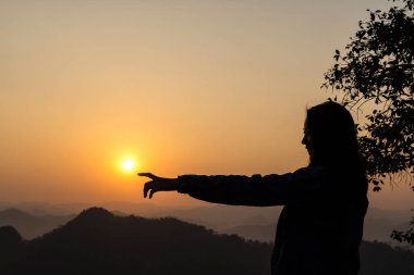 Karanlık güneş Dağları ile arka planda tutan kadın silüeti.