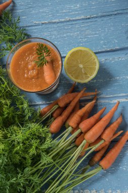 Havuç ve limon ile rustik ahşap masa üzerinde taze havuç güler yüzlü cam üstten görünüm.