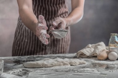 Adam masada ekmek çörekler hazırlama görünümünü kırpılmış.