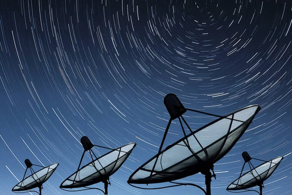 Big black Satellite Dishes on star trail sky background