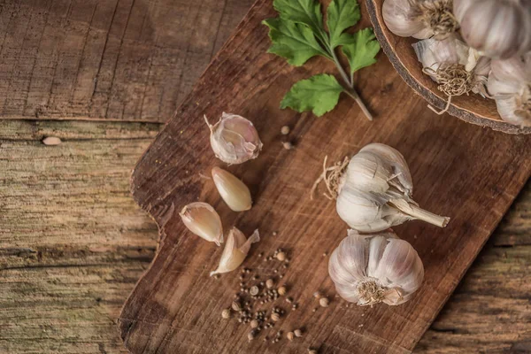 Knoblauchzwiebeln Mit Pfeffer Und Kräutern Auf Holzbrett — Stockfoto