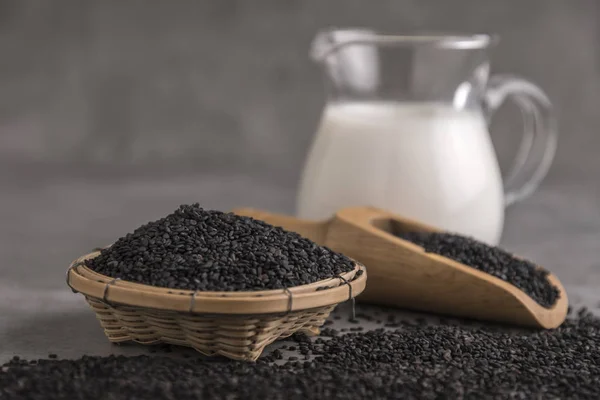 Soybean milk with black sesame on dark background.