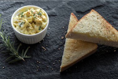 Katı pişmiş yumurta ve hardal ile tost üstten görünüm siyah taş plaka üzerinde