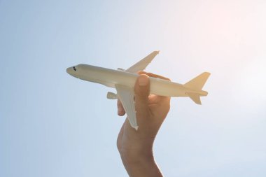 Uçak model güneş ışığı ile gökyüzü arka plan üzerinde insan elinde.