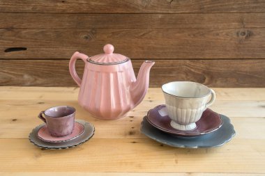 Demlik çay bardaklarından ve ahşap masa ahşap duvar arka plan ile plakaları ile.