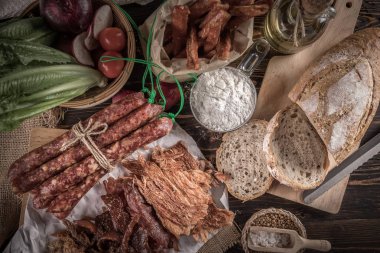 Kesme sosis, ekmek ve ahşap masa üzerinde tedavi et gıda kompozisyonu.