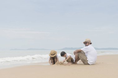 Asya Baba ile iki oğlu kumsalda oynarken