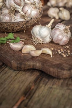 Sarımsak ampuller biber ve ahşap tahta üzerinde otlar ile.