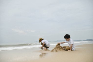 İki çocuk kumsalda birlikte oynama