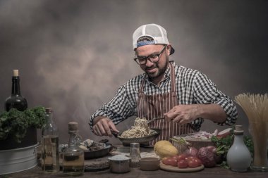 Mutfakta spagetti hazırlanıyor kareli gömlekli sakallı Şef