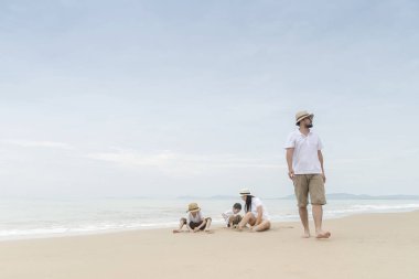 Sahilde iki çocukla Asya Aile.