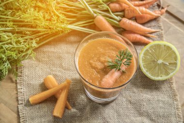 Taze havuç güler yüzlü rustik ahşap masa üzerinde cam tonda resim.