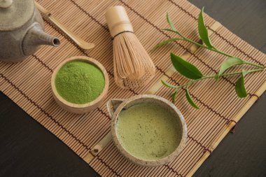 Bambu peçete üzerinde organik yeşil Matcha çay üstten görünüm.