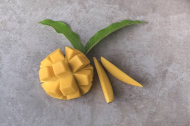 Mango koyu arka plan üzerinde yeşil yaprakları ile dilimlenmiş