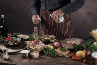 Cook makarna mutfak tarihinde deniz ürünleri ile hazırlama kahverengi önlük kırpılmış görünümü.