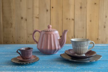 Çaydanlık teacups ve plakaları ahşap duvar arka plan mavi ahşap tablo.