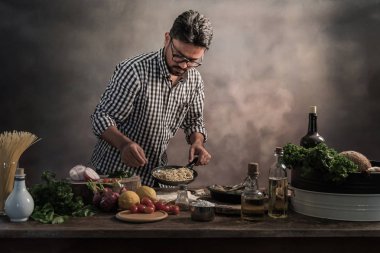 Mutfakta spagetti hazırlanıyor kareli gömlekli sakallı cheef