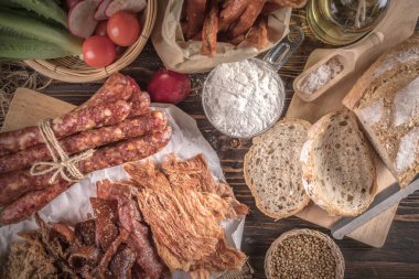Ekmek lezzetli adet dilimlenmiş jambon, sosis, domates ahşap tablo.