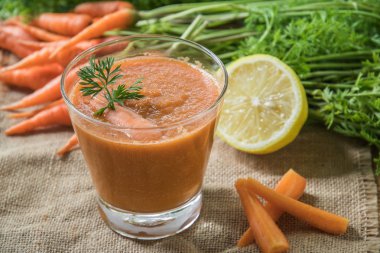 Rustik ahşap masa üzerinde taze havuç güler yüzlü cam görünümü Kapat.