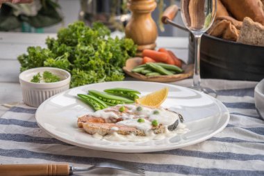 Limon ve beyaz tabakta sebze ızgara somon biftek.