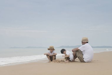 Asya Baba oğulları kasvetli gün kumsalda oynarken