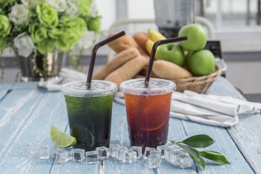 Ahşap masa üzerinde düzenlenmiş bardaklarda limon çay İtalyan soda