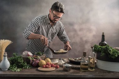 Mutfakta spagetti karıştırma aşçı sakallı.