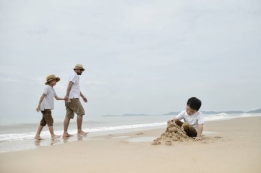 Asya Baba oğulları kasvetli gün kumsalda oynarken