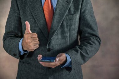 Cep telefonuyla ok işaret gösteren işadamı el.