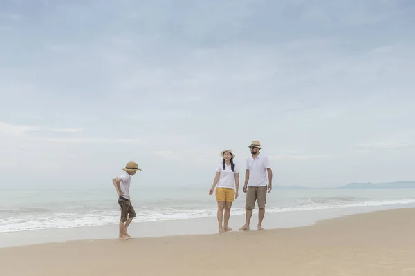 Happy asian family with son on beach together.