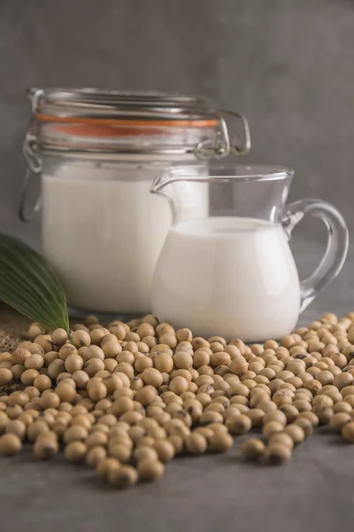 Close view of soybeans and milk in glass jars.